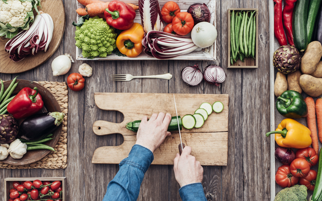 Photo of person cutting vegetables on cutting board
